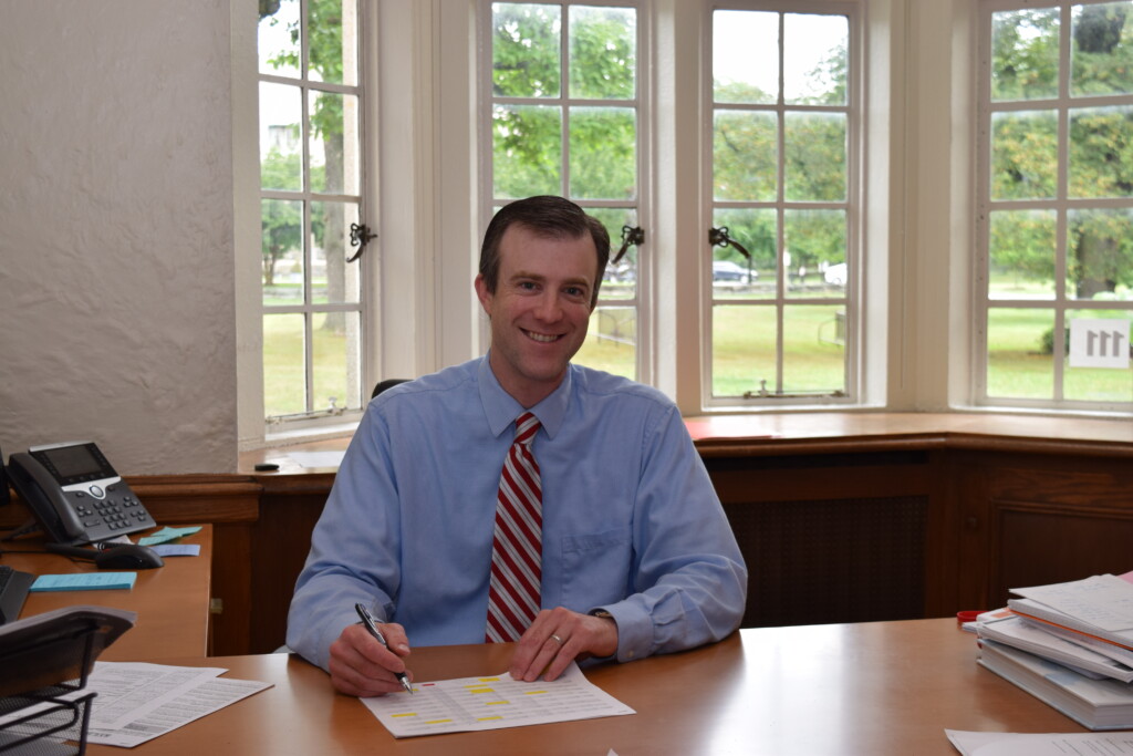 Derek Schuelein Rye High School Principal - at desk