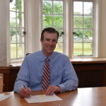 Derek Schuelein Rye High School Principal - at desk