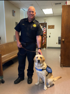 Rye PD Lieutenant Scott Craig with a service dog from Blue Path