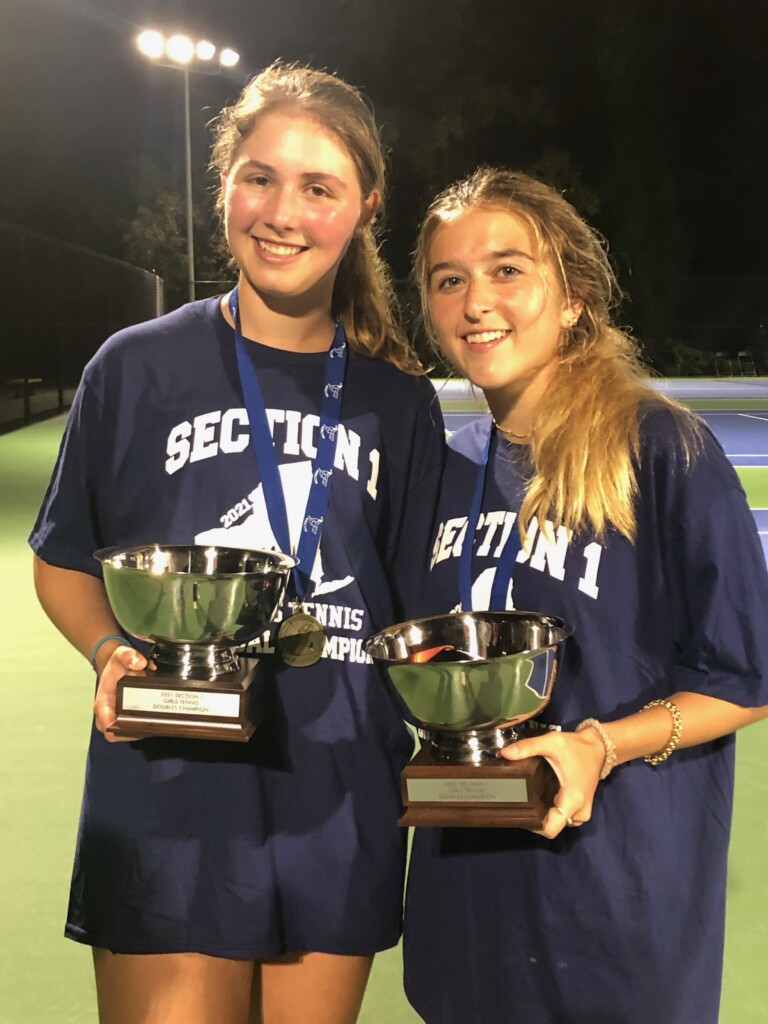 (PHOTO: Juliette Stone and Charlotte Ausfahl pose with their hardware after capturing the Section title for Rye Girls Varsity Tennis on October 13, 2021.)