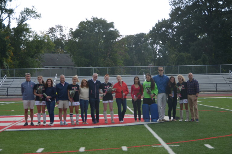 (PHOTO: Rye Girls Varsity Field Hockey seniors with family members for senior day.)