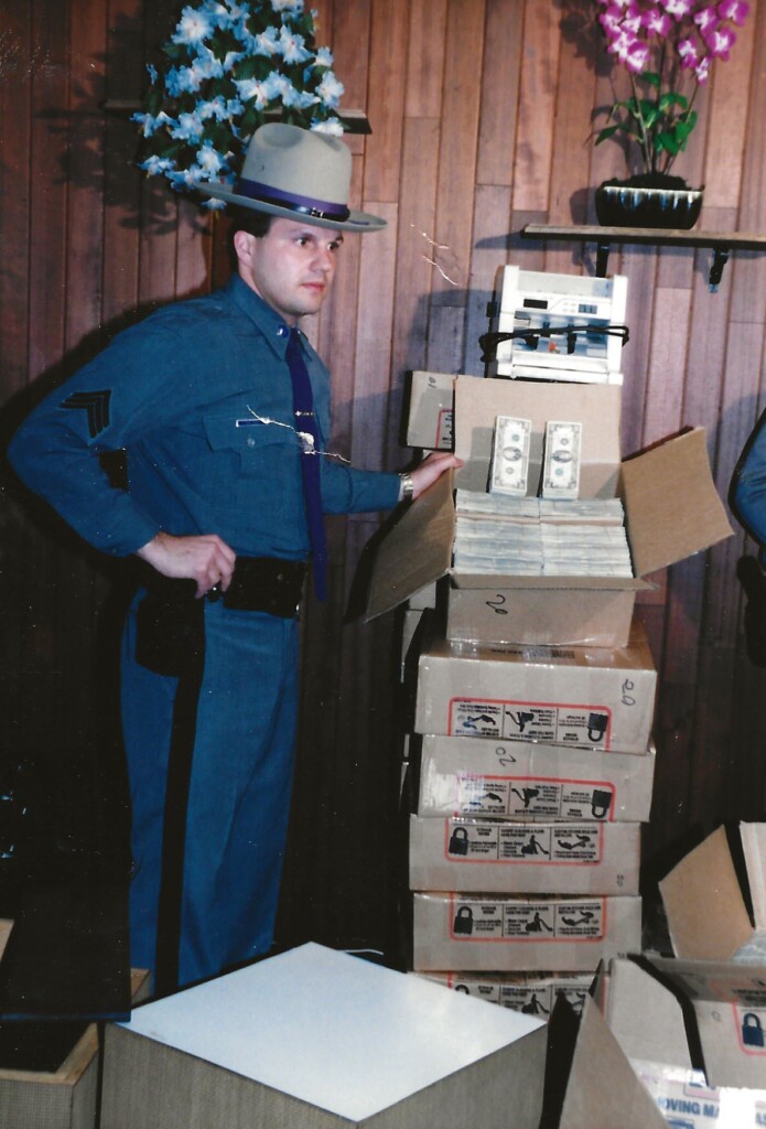 (PHOTO: The six million dollar man. New York State Trooper Kopy standing next to over $6 million dollars in 1992. The cash was seized from a home as part of a money laundering case.)