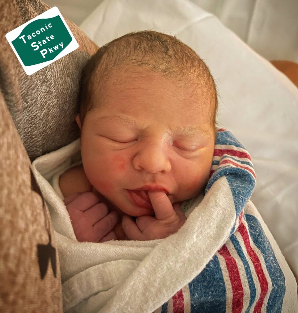 (PHOTO: Rye Police Officer Chad Delgado and his wife welcomed their new arrival on the side of Taconic Parkway.)