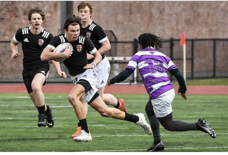 (PHOTO: Rye Boys Varsity Rugby Senior Jack McRedmond attacks with teammates in support.)