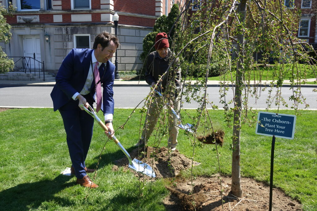 (PHOTO: The Osborn President and CEO Matthew G. Anderson (left) and Osborn Sterling Park Independent Living resident George Berlstein plant the 1,008th tree on their campus on Thursday, April 28, 2022.)