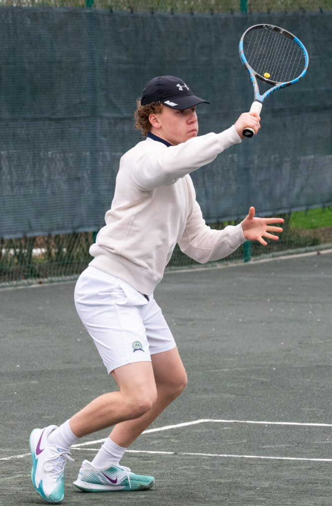 (PHOTO: Rye Boys Varsity Tennis player Cian Keegan hitting topspin on Tuesday.)