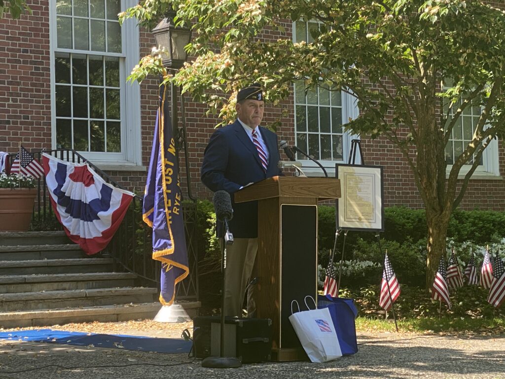 (PHOTO: Legionnaire Terry McCartney reading the Roll of Honor - seventy seven soldiers from the City of Rye - who gave the ultimate sacrifice.)