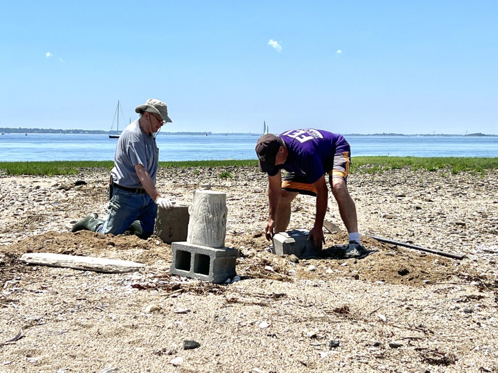 (PHOTO: Konrad Wos and Ed Volpe work on the Hen Island 9-11 Memorial restoration in June.)