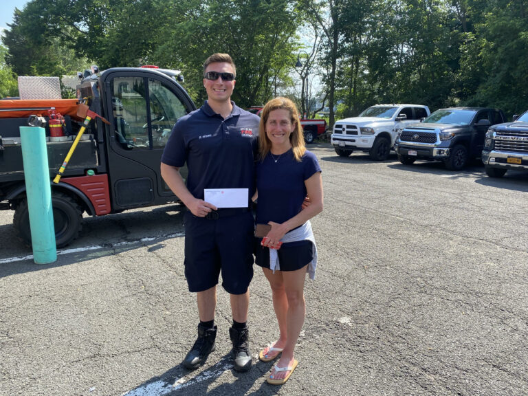 (PHOTO: Rye FD Local 2029 member Danny Archino presents a $4,000 donation to SoulRyeders founder Sandy Samberg.)