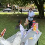 (PHOTO: Adam Levy, executive director of the Rye Arts Center, addresses the addresses pollinator fans on the Village Green.)