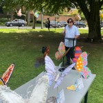 (PHOTO: Adam Levy, executive director of the Rye Arts Center, addresses the addresses pollinator fans on the Village Green.)