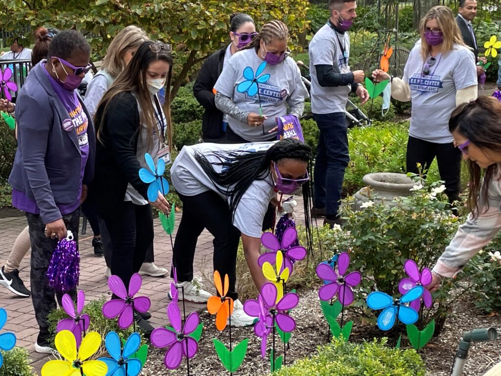 (PHOTO: Participants at the Walk to End Alzheimer’s disease planting flowers of support and remembrance for those who are currently battling Alzheimer’s or those loved ones lost to the disease.)