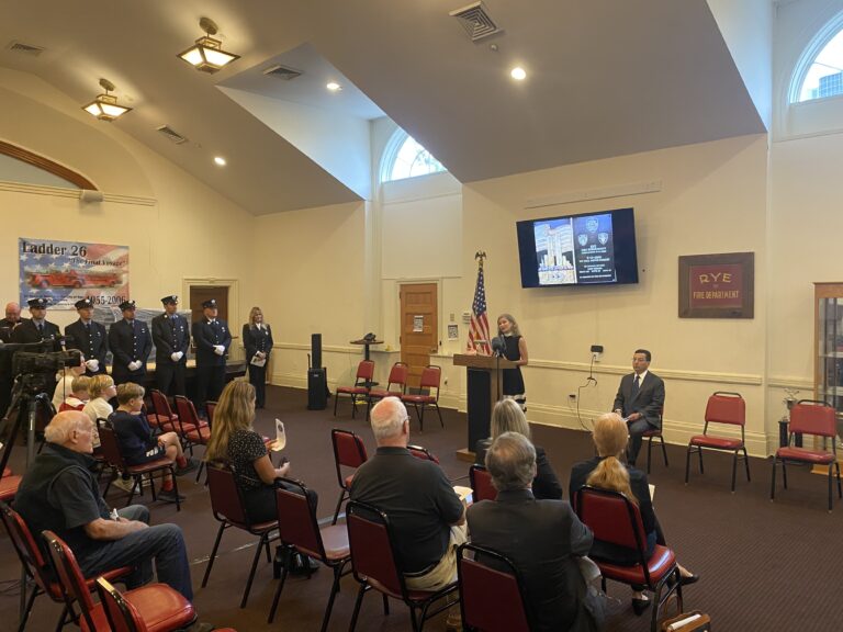 (PHOTO: Reverend Kate Malin of Christ's Church delivering the blessing at the 9-11 Ceremony at Rye FD HQ on September 11, 2022.)