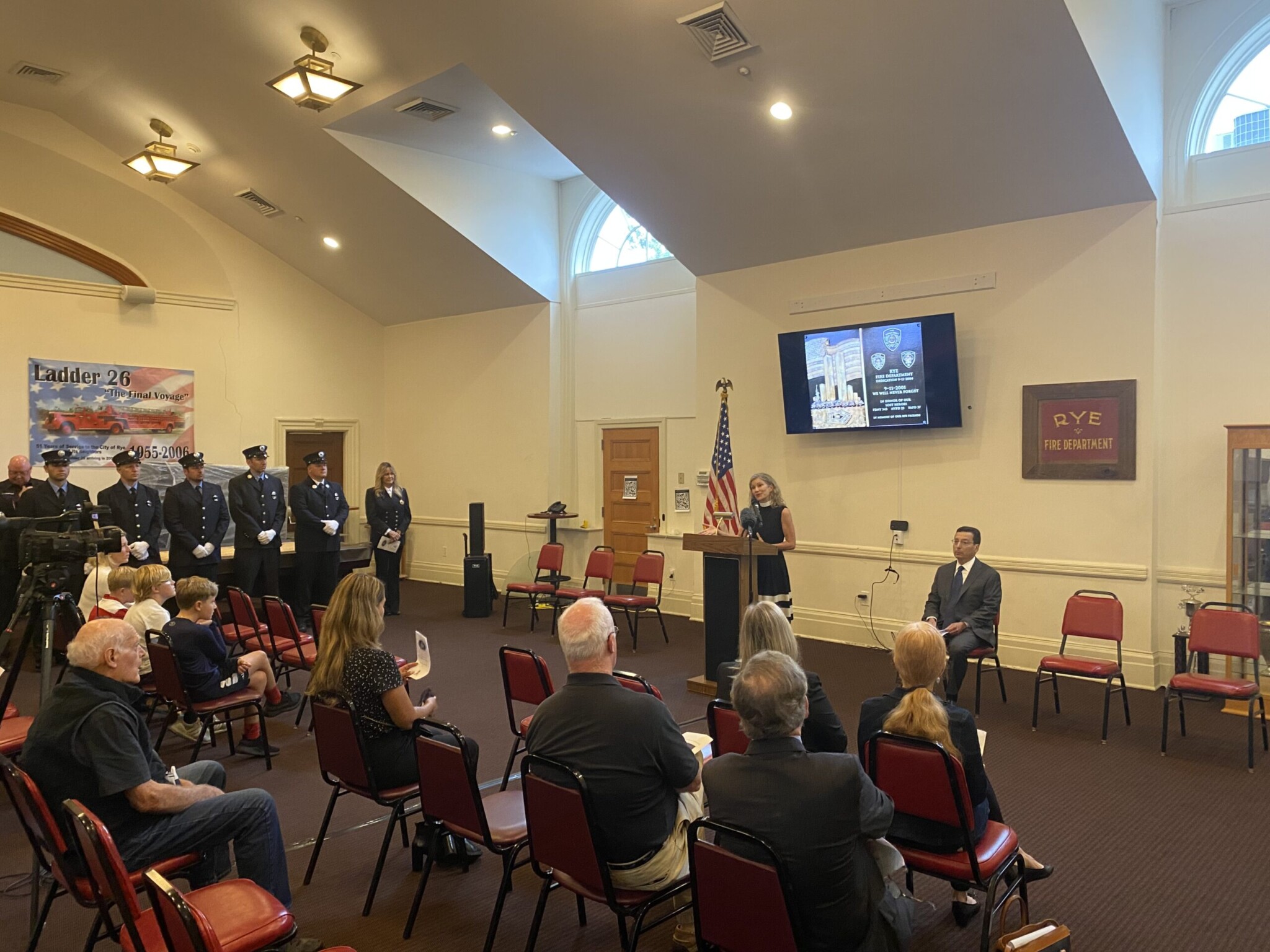 (PHOTO: Reverend Kate Malin of Christ's Church delivering the blessing at the 9-11 Ceremony at Rye FD HQ on September 11, 2022.)