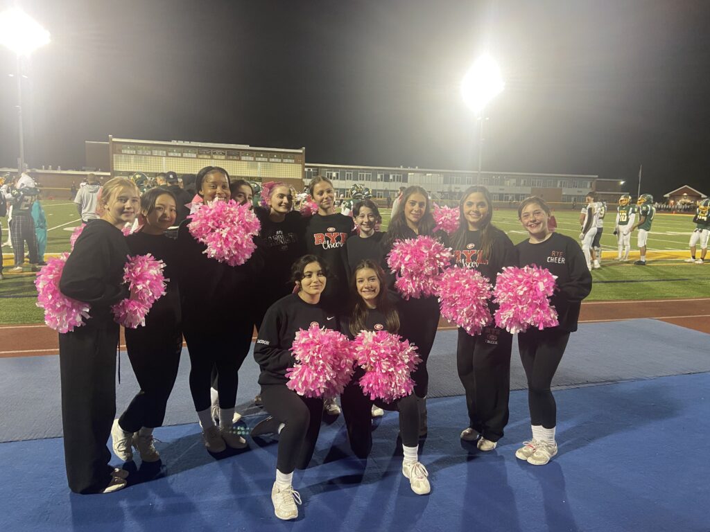 (PHOTO: Rye Girls Varsity Cheerleading kept the pink spirit going on Friday night at Lakeland.)