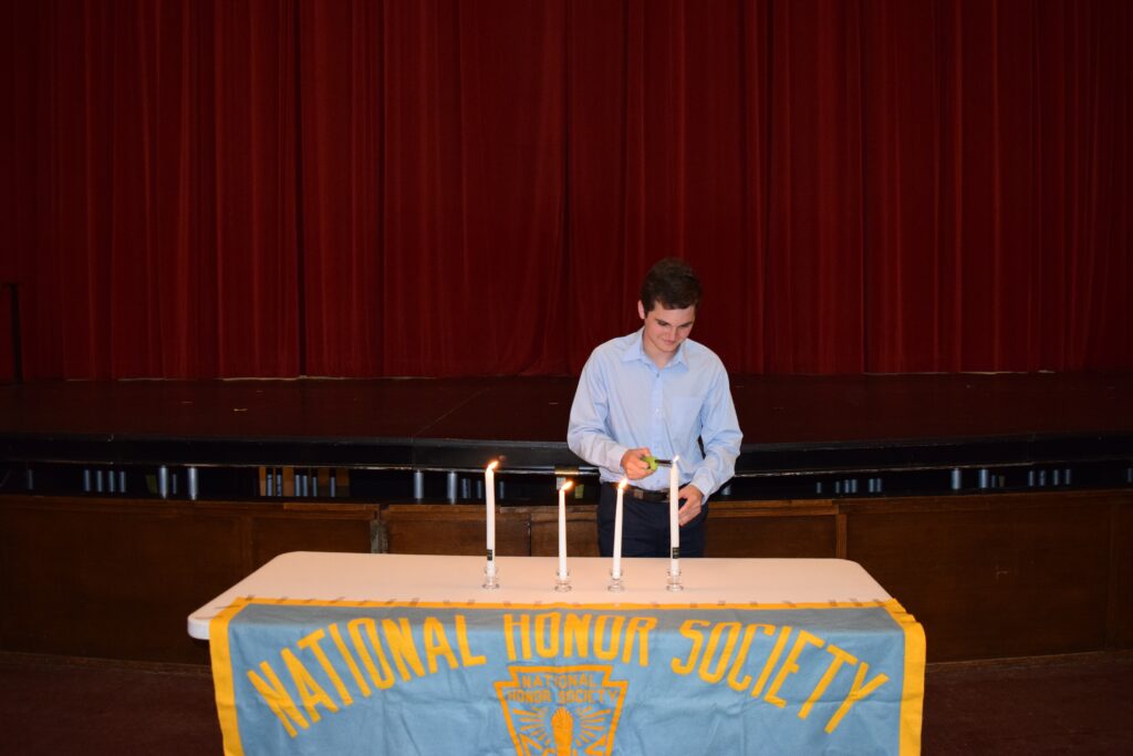 (PHOTO: Ben Mayer lit the Candle of Character at the National Honor Society Induction on Monday, October 3, 2022 at Rye High School.)