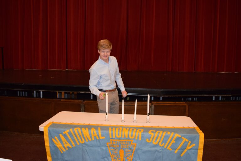 (PHOTO: Charles Reddoch lit the Candle of Scholarship at the National Honor Society Induction on Monday, October 3, 2022 at Rye High School.)