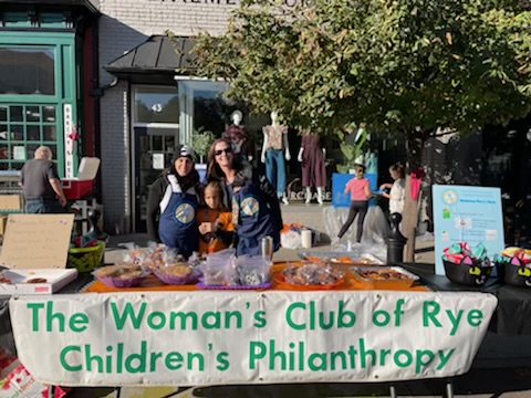 (PHOTO: Rye residents Viviana Torregrossa and Lizzy Parks sell baked goods, candy and other treats to help support several Rye not-for-profits through Children’s Philanthropy at the 68th annual Halloween window painting in Rye.)