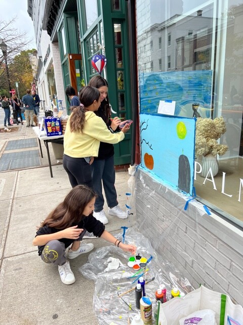 (PHOTO: 6th graders Vaughn Ibrahim, Eva Gupta and Manuela Fernandes work together to create a festive window while being extra careful to keep their workspace at Palmer & Purchase clean and paint-free.)