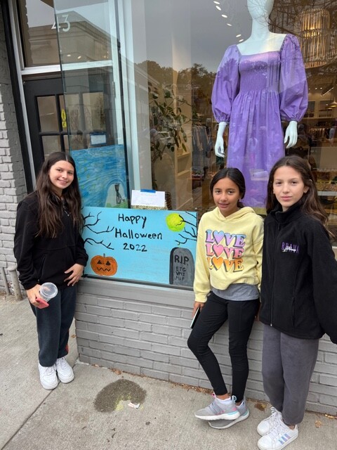 (PHOTO: 6th graders Vaughn Ibrahim, Eva Gupta and Manuela Fernandes work together to create a festive window while being extra careful to keep their workspace at Palmer & Purchase clean and paint-free.)