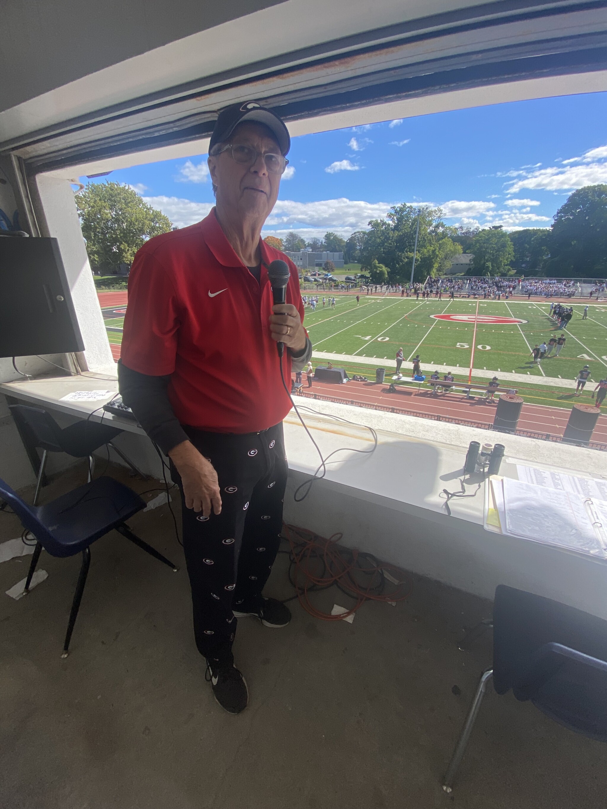 (PHOTO" Steve “The OG” Feeney in the press box at Rye High School's Nugent Stadium, 2022.)