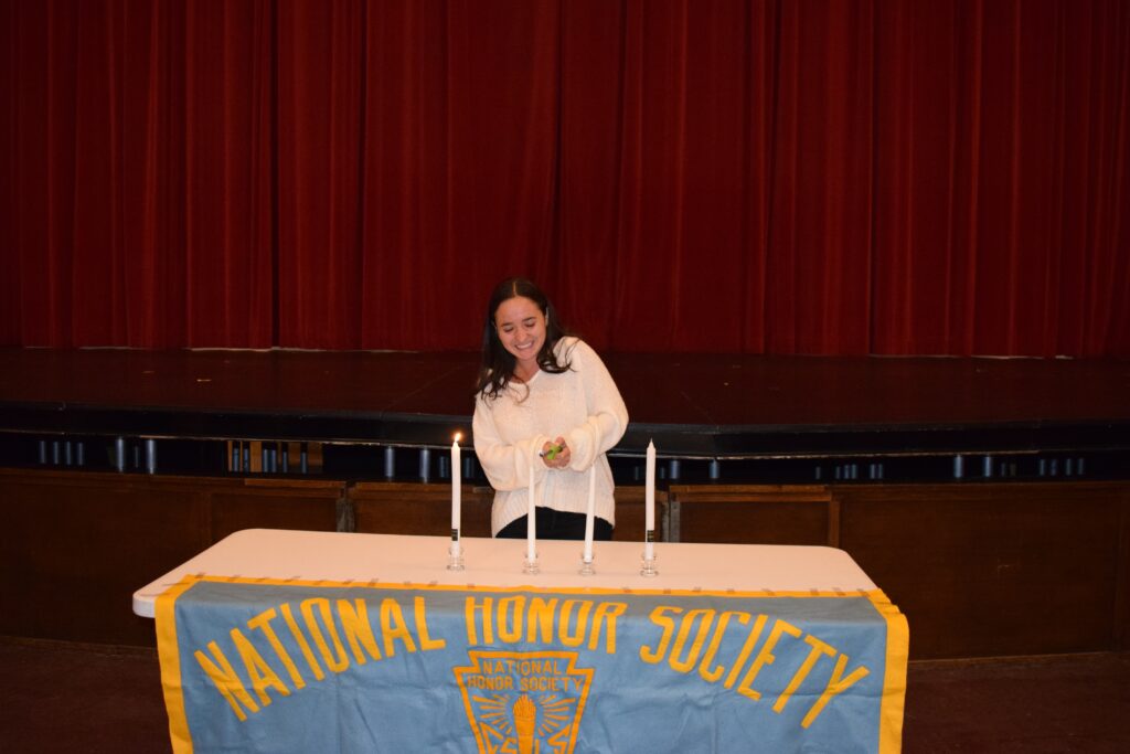 (PHOTO: Marissa Fink lit the Candle of Leadership at the National Honor Society Induction on Monday, October 3, 2022 at Rye High School.)