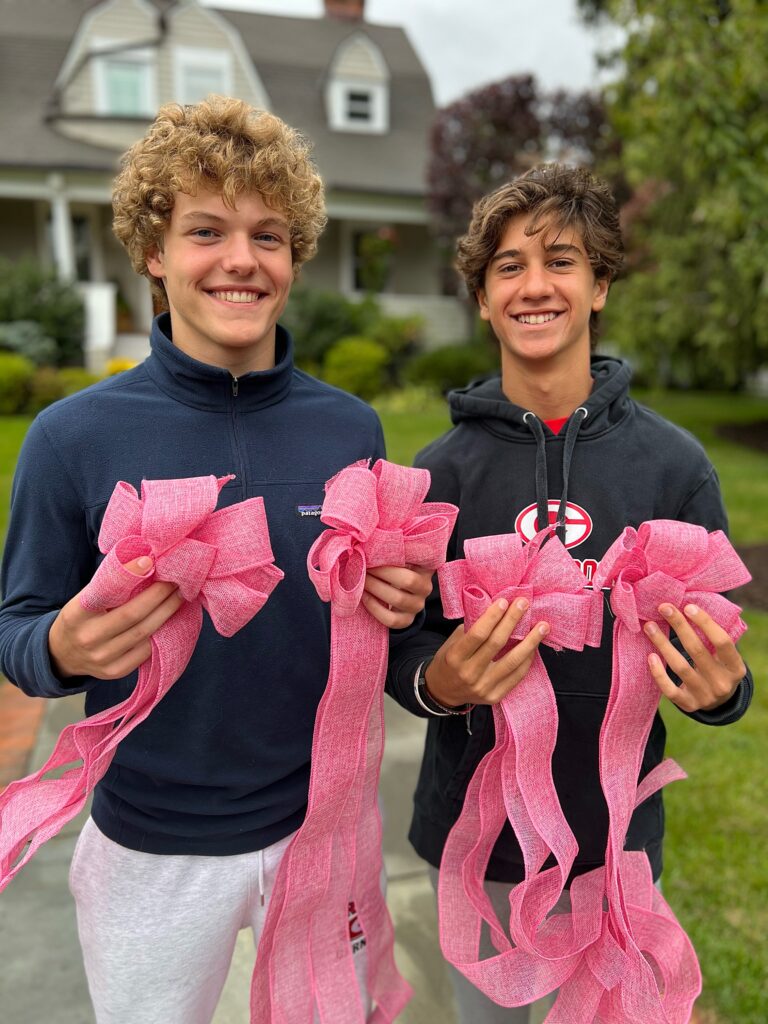 (PHOTO: Rocklan Boisseau and Alex Leisengang tying ribbons throughout Rye on Saturday for TieTheTownPink. Photo credit: Melissa Boisseau.)