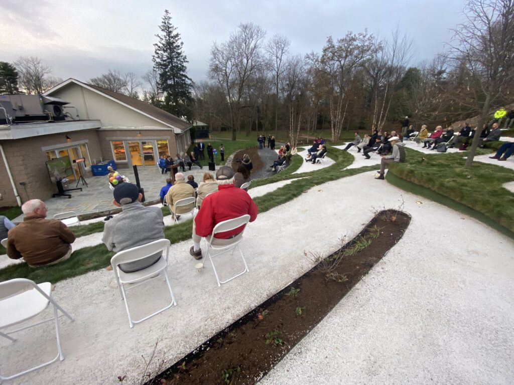 (PHOTO: Rye Mayor Josh Cohn spoke about Rec Superintendent Sally Rogol at the new amphitheater on Tuesday.)