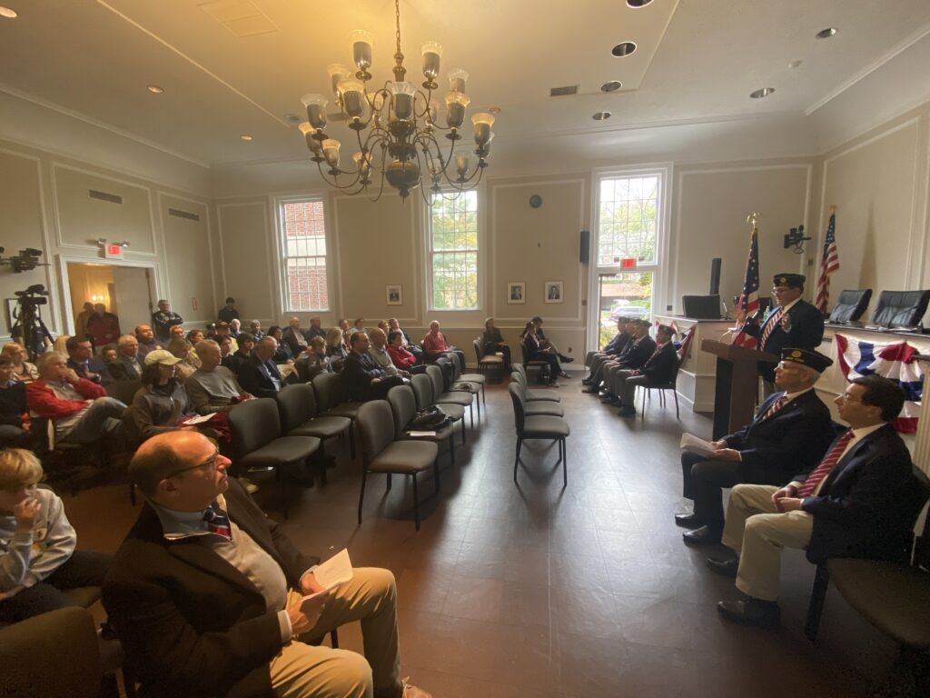 (PHOTO: Under the impending threat of rain, Veterans Day ceremonies were moved from the village green to city council chambers at Rye City Hall on Friday.)