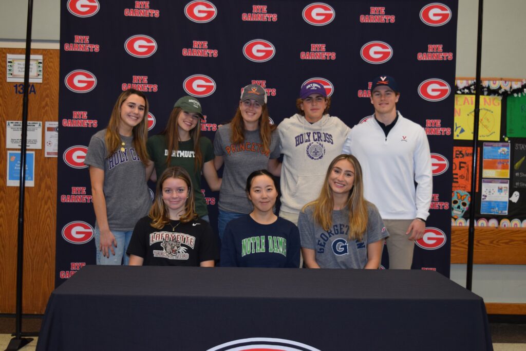 (PHOTO: Eight Rye High School seniors have committed to play Division 1 sports at college/university. Back row l to r: Mackenzie Chimento (lacrosse, Holly Cross), Elizabeth Madigan (crew, Dartmouth), Eleanor Smith (crew, Princeton), Toma Sellar (crew, Holy Cross), Kian McCarthy (lacrosse, UVA). Front row, l to r: Caitlyn Doyle (track and field, Lafayette), Joyce Kang (crew, Notre Dame), Lily Shaaban (crew, Georgetown).)