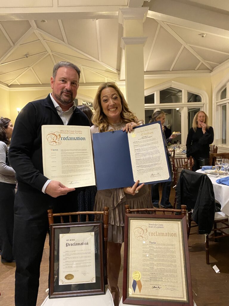 (PHOTO: Brian Jackson, President of the Rye City Lions Club, and Staci Ramachandran, 2022 Recipient of the James A. and Marian M. Shea Community Service Award from the Rye City Lions Club.)