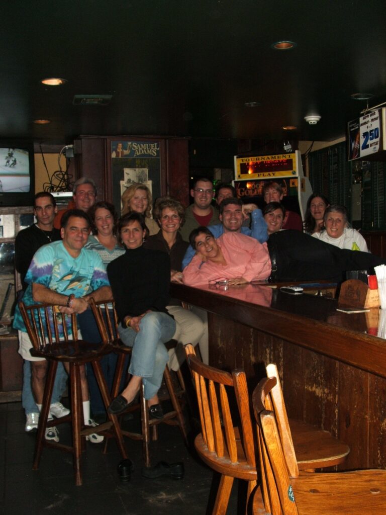 (PHOTO: Rogol's 37 years: a staff party at Rye Roadhouse. From left to right: John DeMarco, Frank Cecere, Dennis Hurlie, Randy Cohen, Janet O’Neill, Julianne May, Laura Schilling, Matthew Nordt, Kevin Cook, Danielle Angilleta, Diane Moran, Cara Barnhardt, Sophie Diamond.)