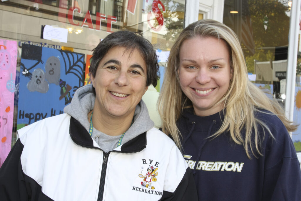 (PHOTO: Rogol's 37 years: Sally Rogol and the heir apparent Erin Mantz at the Halloween window painting circa 2018.)