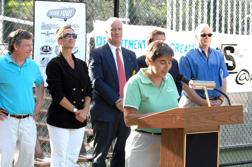 (PHOTO: Rogol's 37 years: The Rye Rec Skate Park Opening in 2007> Sally Rogol at the podium. Behind her: Steve Otis, Joanne O’Malley, Bob Cypher, Doug French, Bill Rodriguez (then superintendent).)