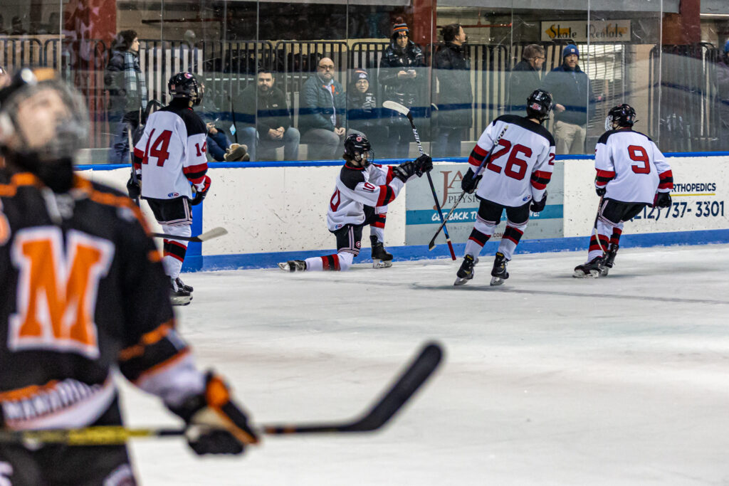 (PHOTO: Rye Varsity Boys Hockey player Henry Bagley celebrates one of his 3 goals with his teammates on Wednesday vs. Mamaroneck.)