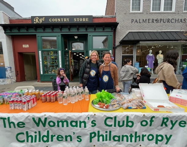 (PHOTO: Children’s Philanthropy of the Woman’s Club of Rye bake sale table at Halloween Window Painting in downtown Rye (Megan Pellarin, Christine Groves).)