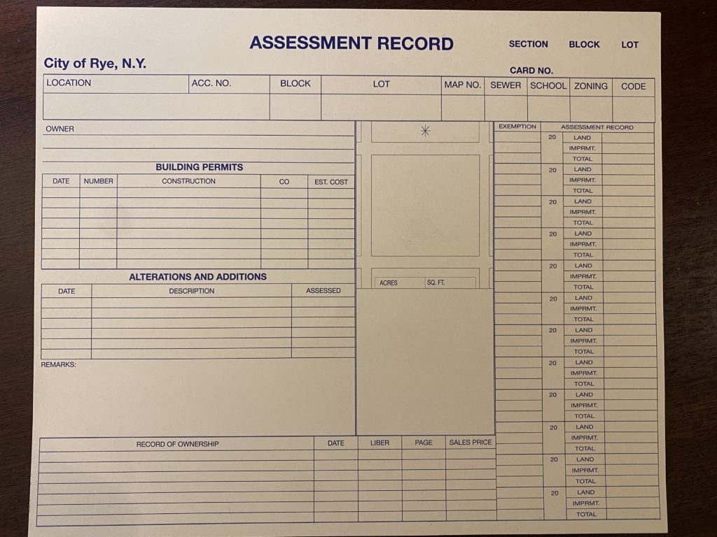(PHOTO: The front side of the Rye City Assessment Office Property Card. Each property card is the tan-ish color of a manila file folder and on its two sides contains hundreds of handwritten data points including permits, alterations and additions, ownership records and various home or land attributes such as square footage, house systems, topography, road access, room counts and depreciation factors.)