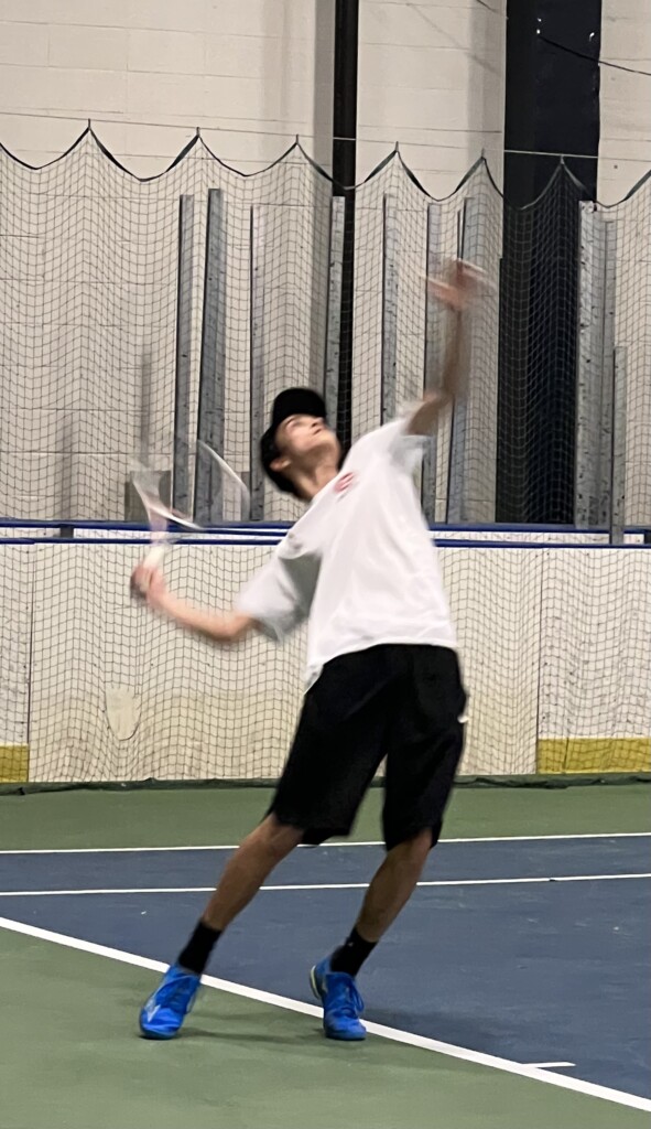 (PHOTO: Alex Gordon of Rye Boys Varsity Tennis serving during the Scarsdale B match Thursday.) 2023-04-20