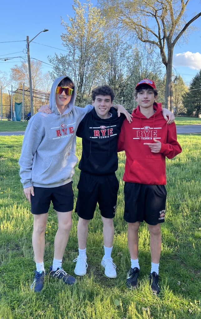 (PHOTO: Rye Boys Varsity Tennis team members Henry Paul, Ty Bibas, Matthew Templeman sporting new school swag on Tuesday.) 2023-04-18