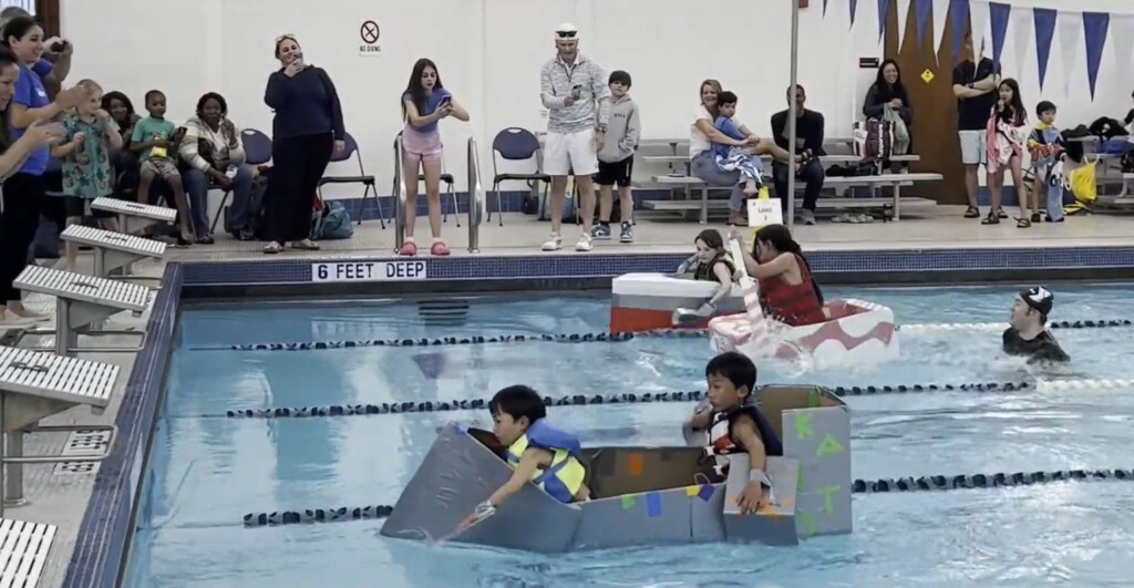 (PHOTO: The 7th Annual Rye YMCA Cardboard Boat Regatta champions, Aoto and Kaito Yamamoto navigate their craft to victory.)