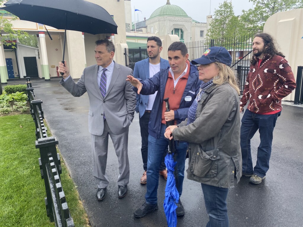 (PHOTO: Nick Singer, managing principal of Standard Amusements (the firm with the long term management contract for the park) (center, in the blue Playland jacket) speaks with Westchester County Board of Legislators local Rye Representative Catherine Parker.)