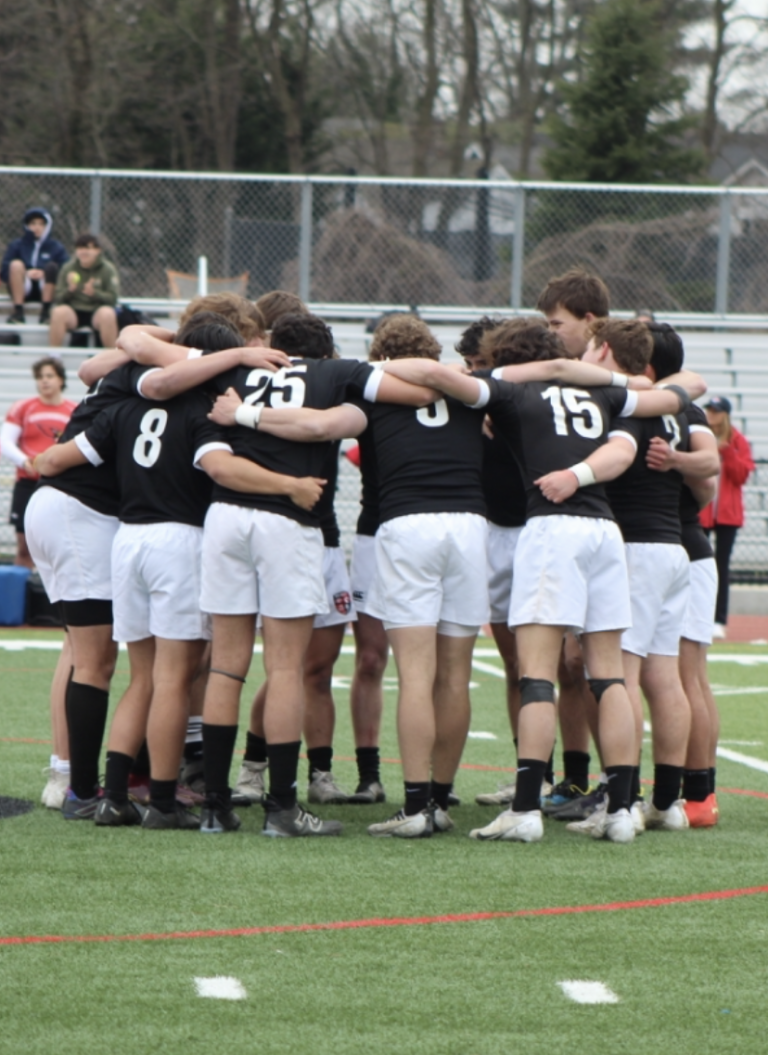 (PHOTO: The 2023 Rye Boys Varsity Rugby team huddled together before the match on Thursday.)