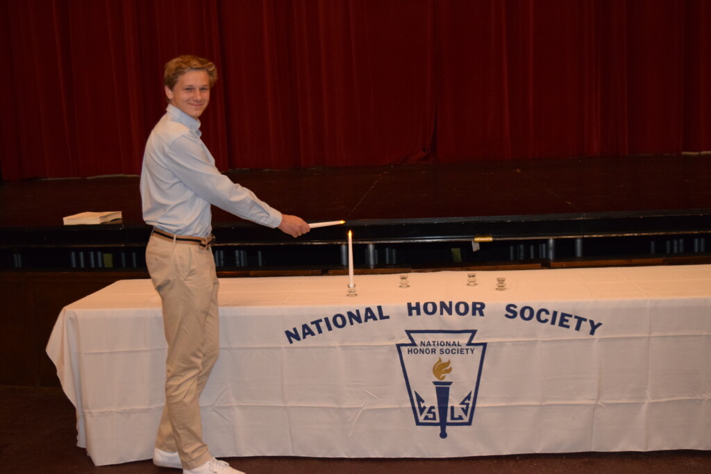 (PHOTO: For the National Honor Society (NHS) ceremony, Niklas Hofmann lit the Candle of Scholarship.)