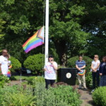 (PHOTO: County Legislator Catherine Parker flaunts her “Drag is Art” t-shirt from the LOFT and speaks to the crowd at the Pride flag raising in Rye Town Park on Saturday, June 10, 2023. Credit: Sierra Desai.)