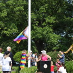 (PHOTO: Influencer Desmond Napoles and young community members raise the Pride flag at 9:30 am in Rye Town Park on Saturday, June 10, 2023. Credit: Sierra Desai.)