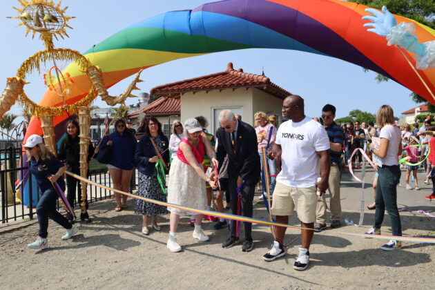 (PHOTO: Town to Rye Councilmember Pam Jaffee and Town of Rye Supervisor Gary Zuckerman cut the rainbow ribbon to commence the Pride parade in Rye Town Park on Saturday, June 10, 2023. Credit: Sierra Desai.)