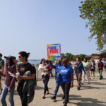 (PHOTO: Community members and supporters parade through Rye Town Park on Saturday, June 10, 2023. Credit: Sierra Desai.)