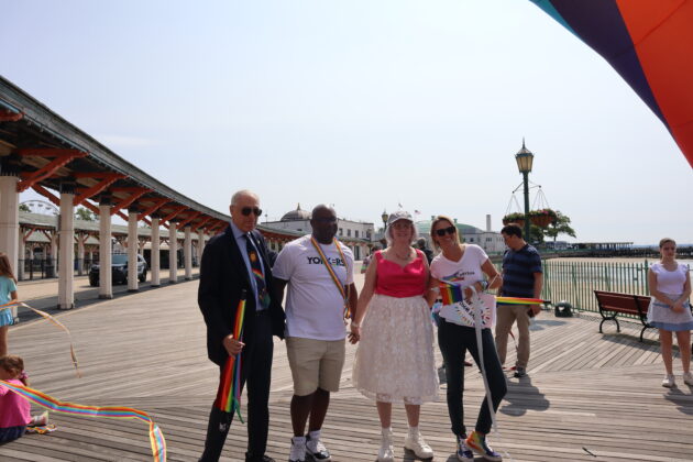 (PHOTO: (from left to right) Town of Rye Supervisor Gary Zuckerman, Congressman Jamaal Bowman, Town of Rye Councilwoman Pam Jaffee, and pRYEde's Amanda Timchak pose at the halfway point of the Pride parade on the PLayland boardwalk on Saturday, June 10, 2023. Credit: Sierra Desai.)