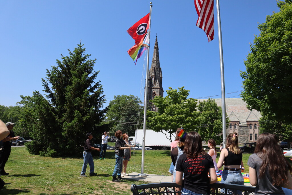 (PHOTO: Two of GSA club’s leaders Odessa Meulbroek and Jos White raise the first flag of the day at Rye High School at 3:00 pm. Credit: Sierra Desai.)