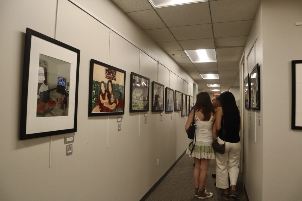 (PHOTO: Students viewing the AP 2D art section of the exhibit in the Central Administration Building. Credit: Sierra Desai.)